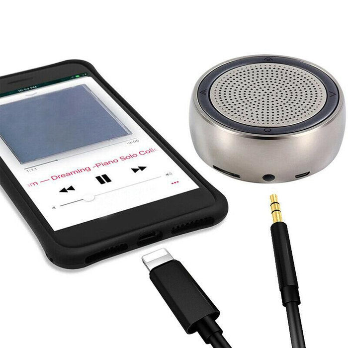 Smartphone with music player app, portable speaker, and audio cable on a white background